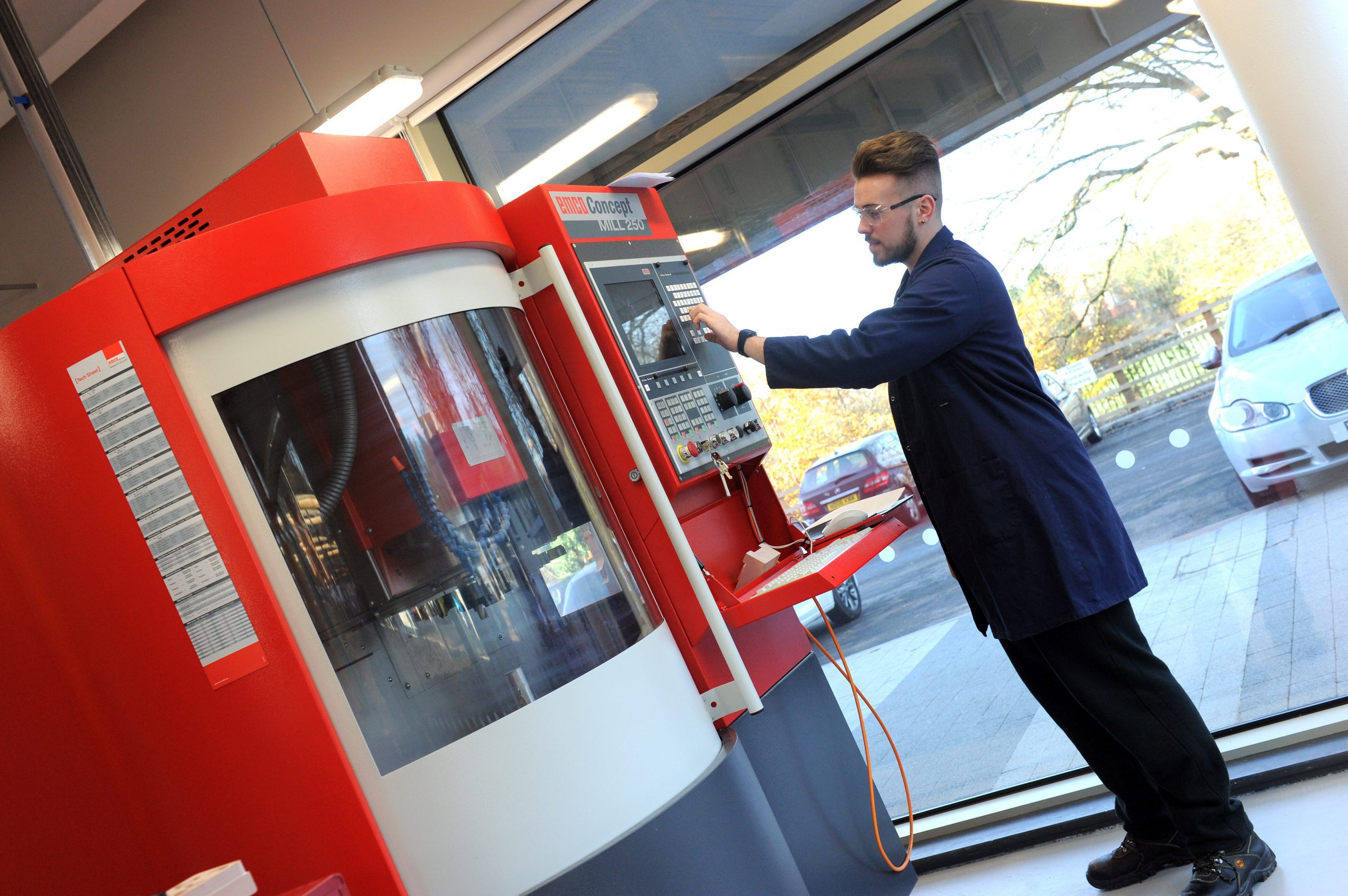 Male engineering student operating a large machine