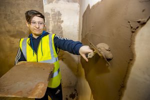 Plastering student applying plaster to a wall